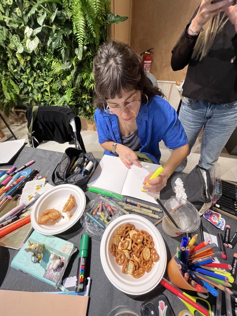 una participante del taller dibujando en el cuaderno